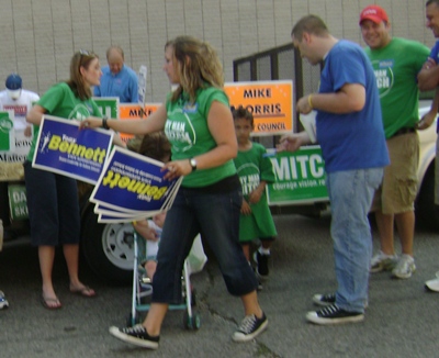 Despite thinking Trevor was a jerk, Whitney was still helping Trevor by handing out Tony Bennett signs. Trevor was helping himself by handing out Tony Bennett stickers. Despite thinking Trevor was a jerk, Whitney was still helping Trevor by handing out Tony Bennett signs. Trevor was helping himself by handing out Tony Bennett stickers.